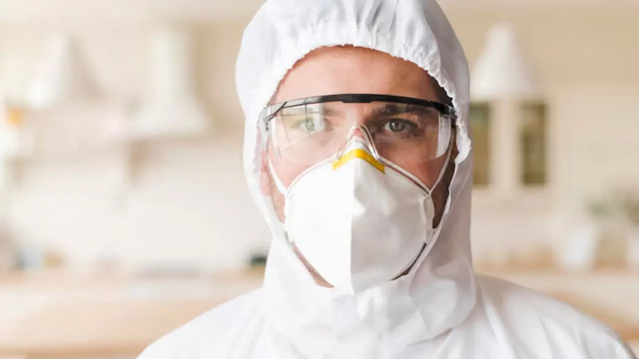 Person in a protective hood, goggles and N95 respirator